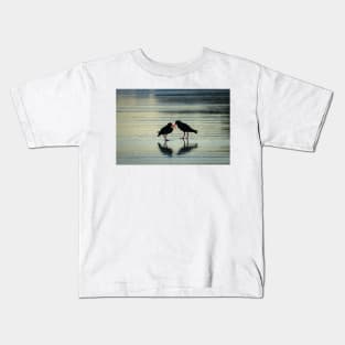 Two black oystercatchers silhouetted with orange beaks crossed, back-lit. Kids T-Shirt